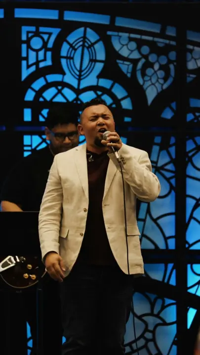 A worship leader singing on stage