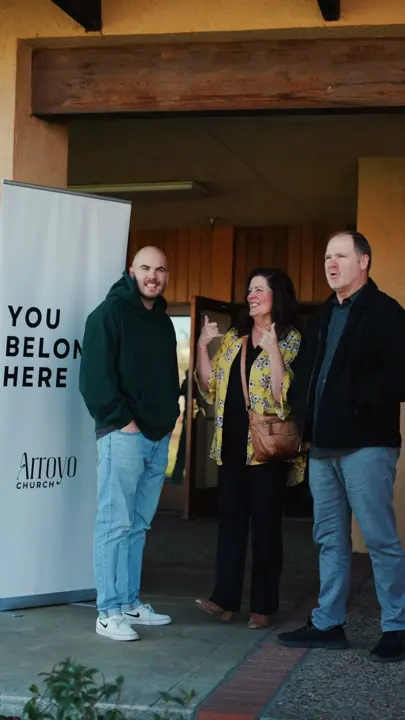 Pastors welcoming guests at a church entrance