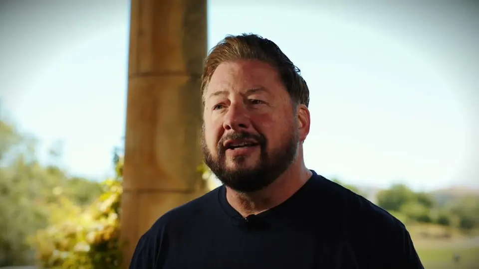 A man speaking on camera outdoors